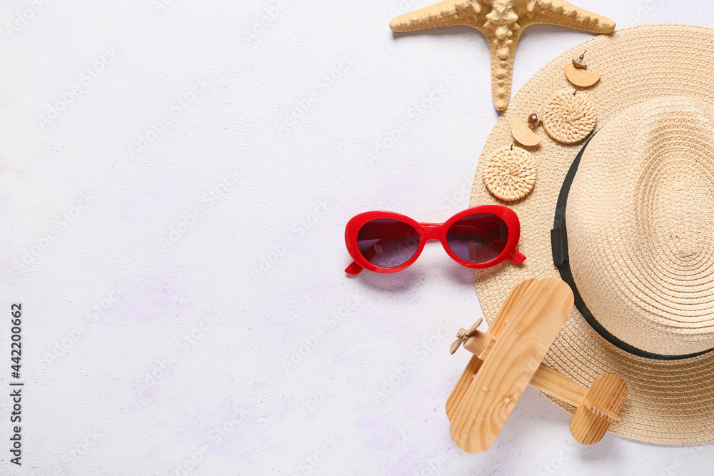 Set of female accessories with sunglasses and wooden airplane on light background