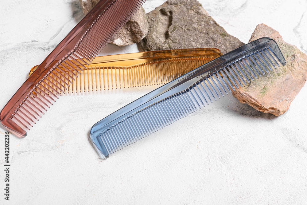 Composition with hair combs and stones on light background