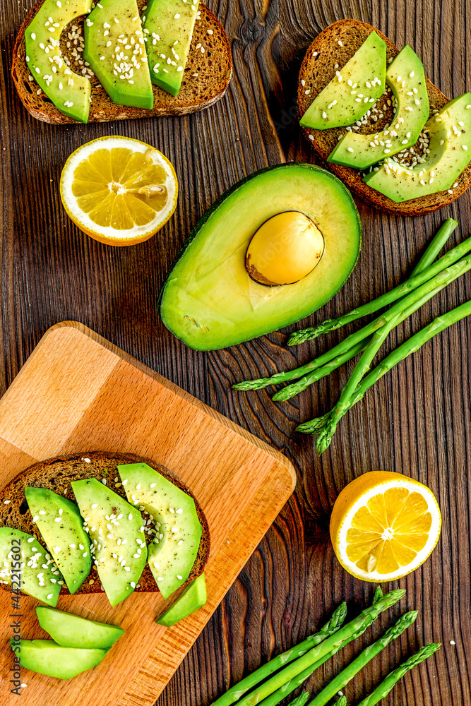 homemade sandwiches with avocado on wooden table background top view