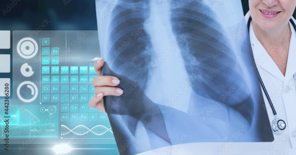 Mid section of female doctor examining x-ray report against medical data processing