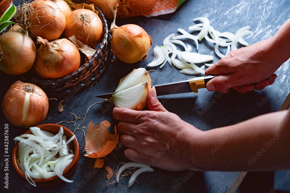 Cebollas y rodajas sobre tabla de cortar de madera y cesto de mimbre. Fondo de alimentos saludables.