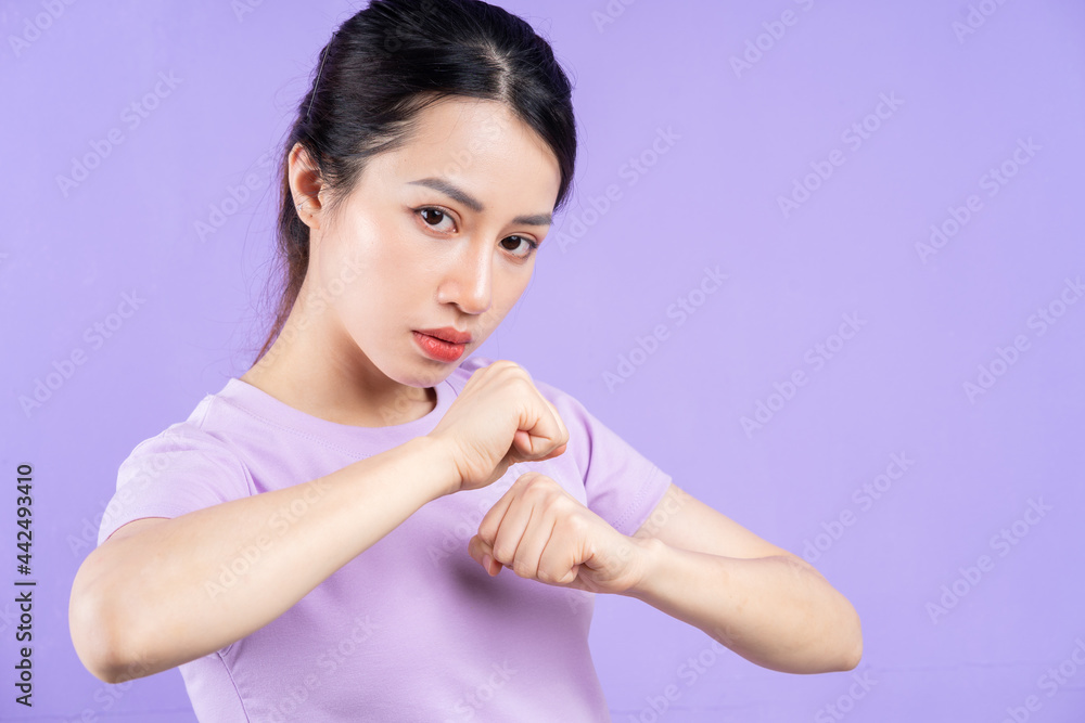 Young Asian woman posing on purple background