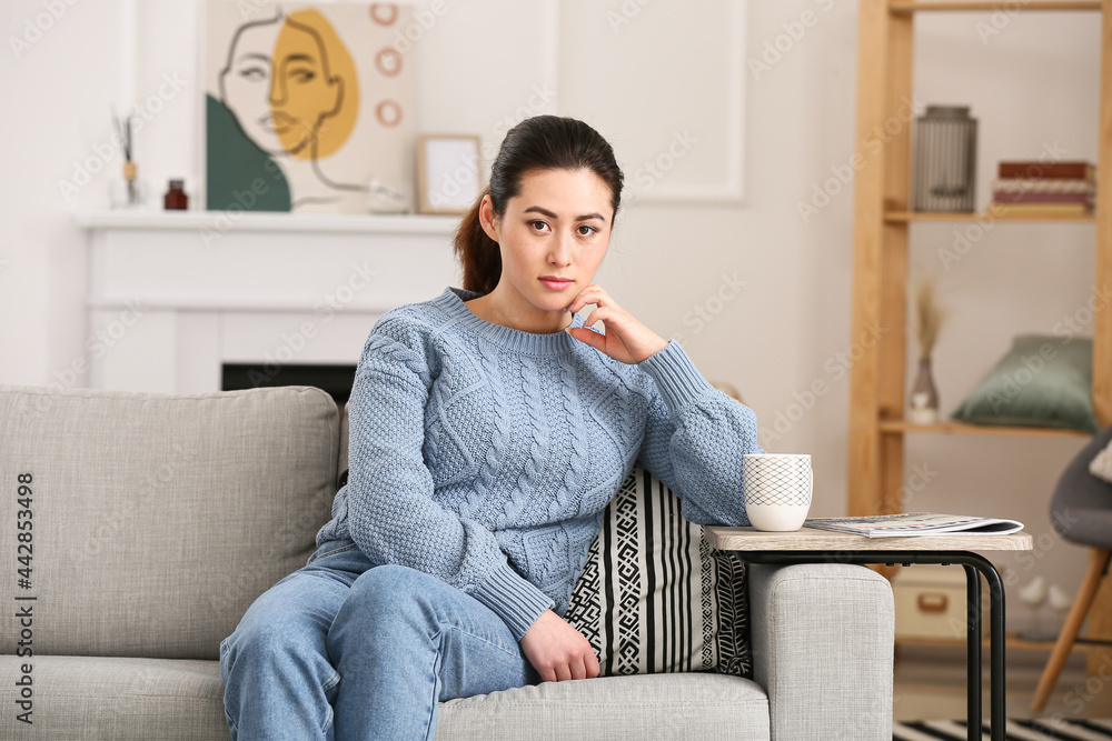 年轻女人坐在家里的沙发上