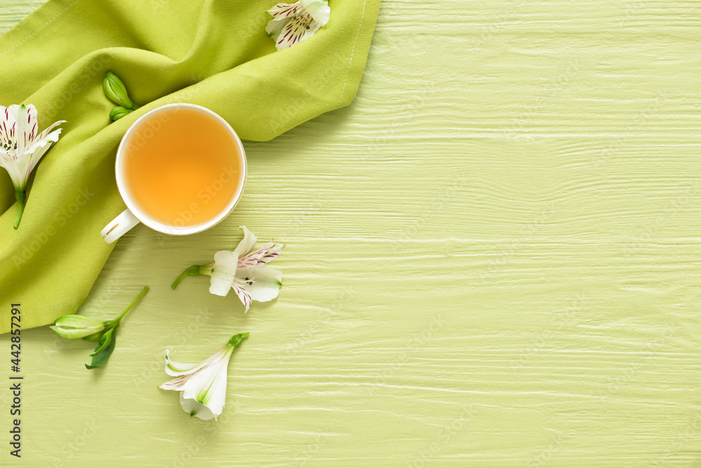 Cup with tasty floral tea on color wooden background