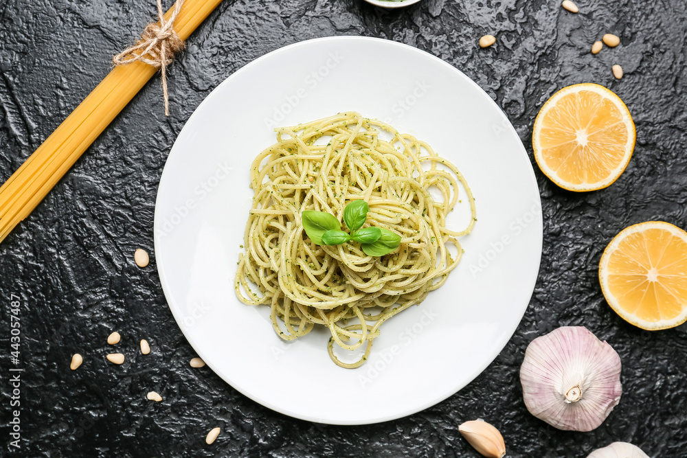 Plate with tasty pesto pasta on dark background