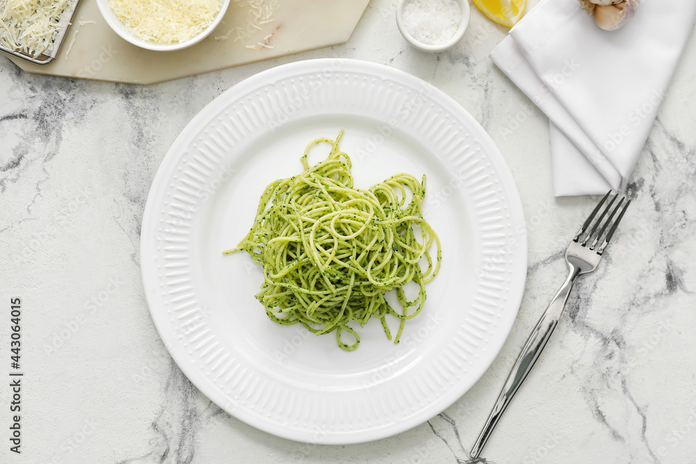 Plate with tasty pesto pasta on white background