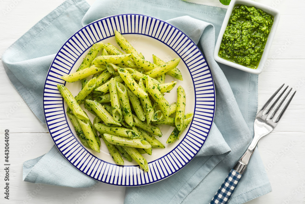 Plate with tasty pesto pasta on table