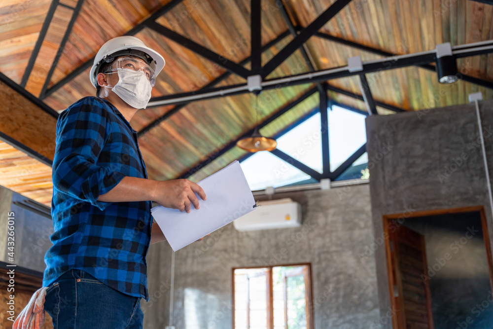 Asian construction engineer technician inspect the wood structure under the roof at construction sit