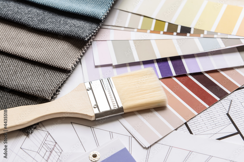 Composition with paint color palettes and fabric samples on house plan, closeup