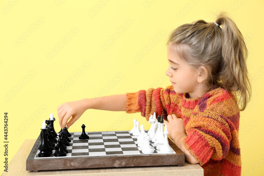 可爱的小女孩在彩色背景下下棋