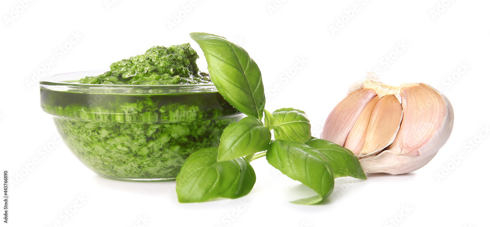 Bowl with fresh pesto sauce, basil leaves and garlic on white background