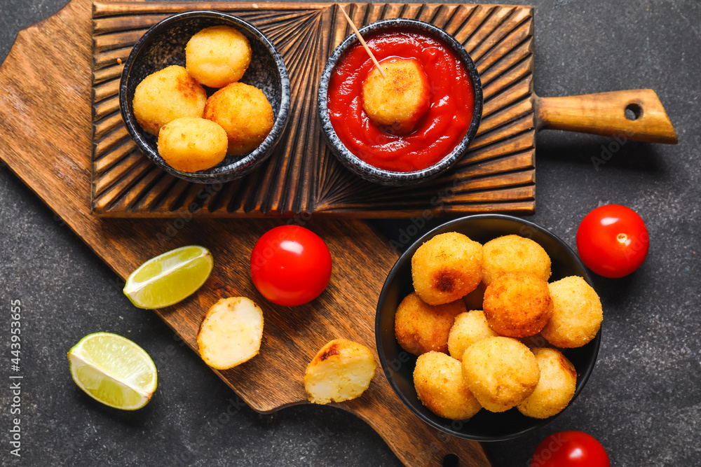 Composition with fried potato balls on dark background