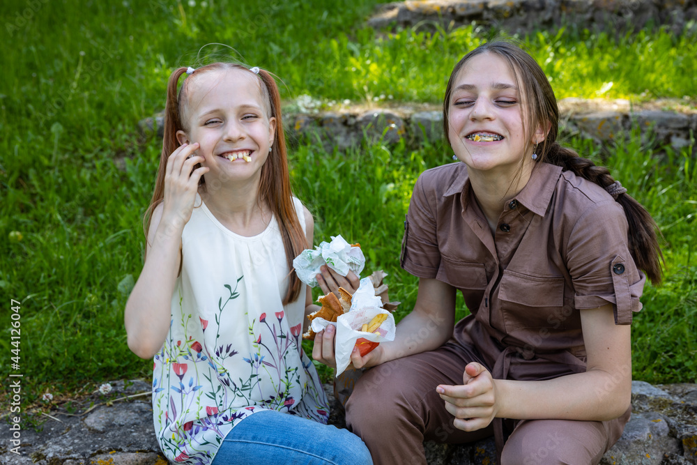 Happy sisters have picnic outdoor