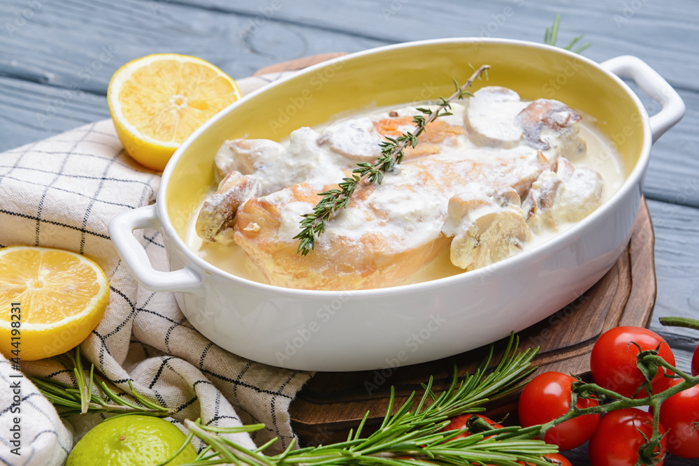 Baking dish with tasty chicken fillet on wooden background