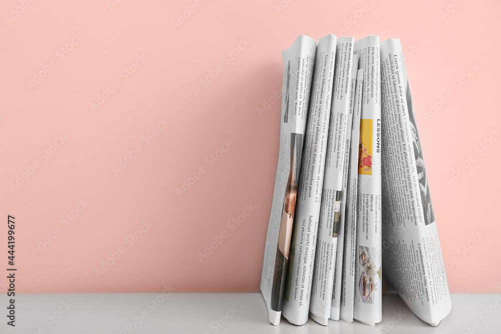 Newspapers on table near color wall