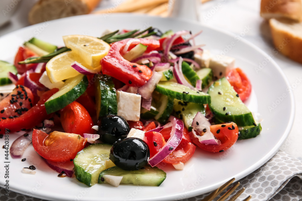 Plate with tasty Greek salad on table, closeup