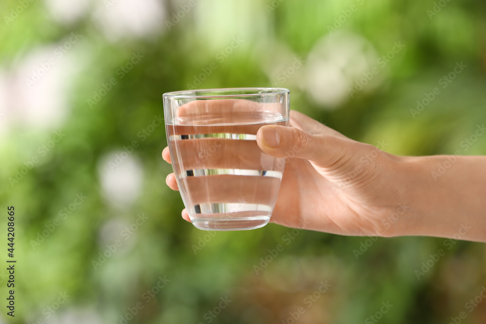 女性手拿一杯室外新鲜冷水，特写