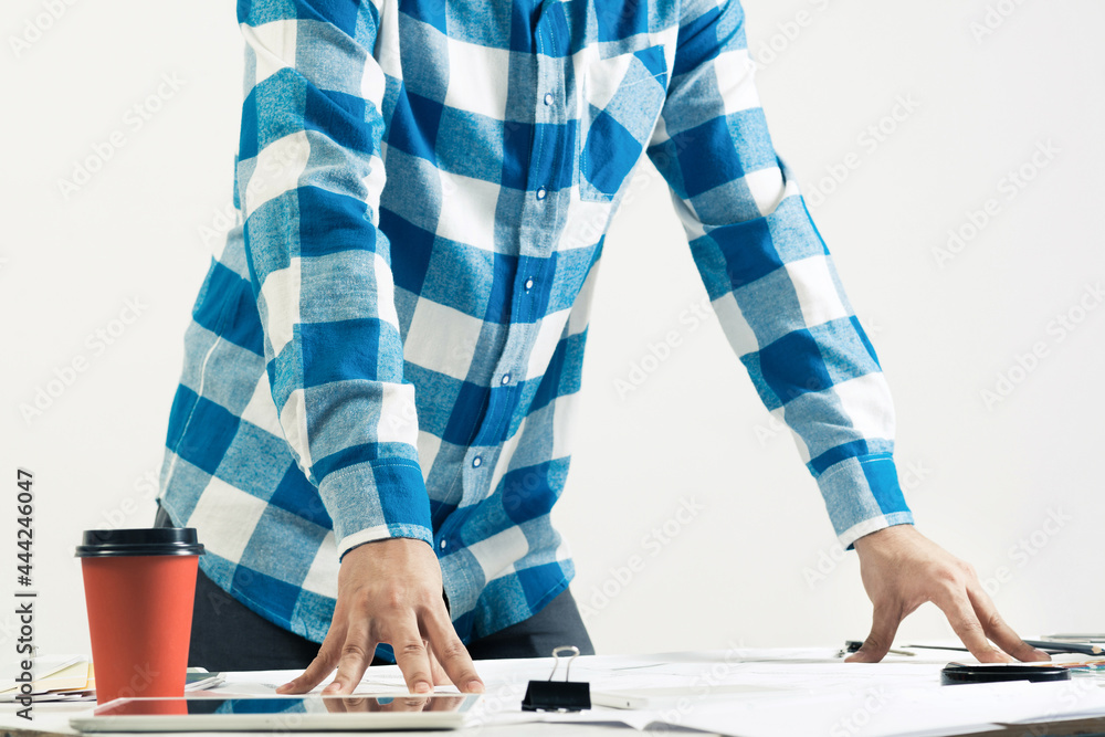 Architect standing near desk with blueprints