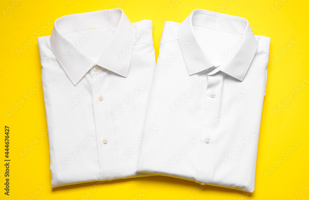 Stylish male shirts on color background