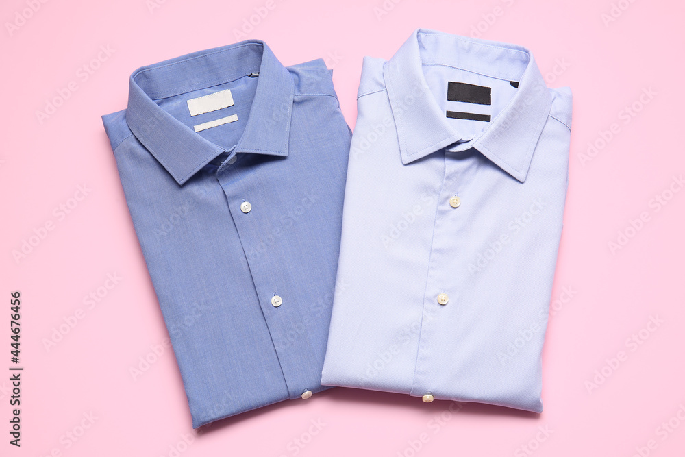 Stylish male shirts on color background