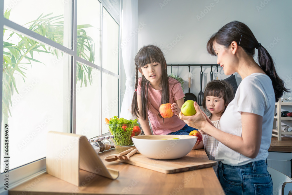 亚洲美女妈妈带两个小女儿做蔬菜沙拉