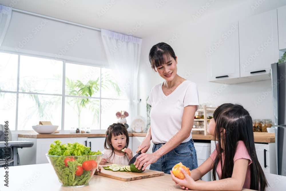 亚洲美女妈妈带两个小女儿做蔬菜沙拉