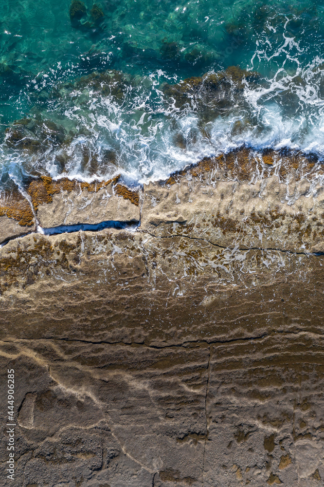 海浪在岩石海岸上破碎，空中垂直拍摄