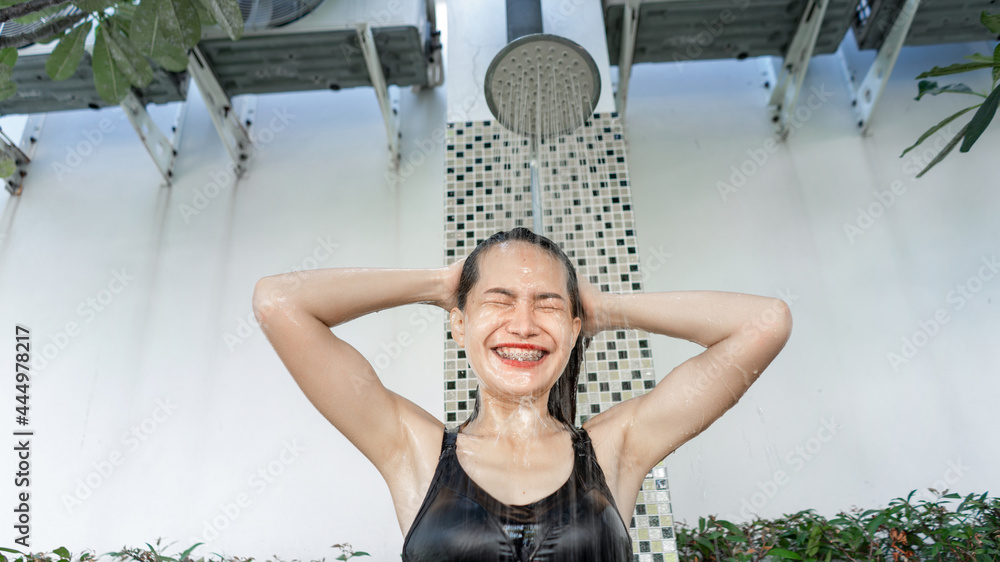 女子洗头，女子游泳前在室外淋浴。