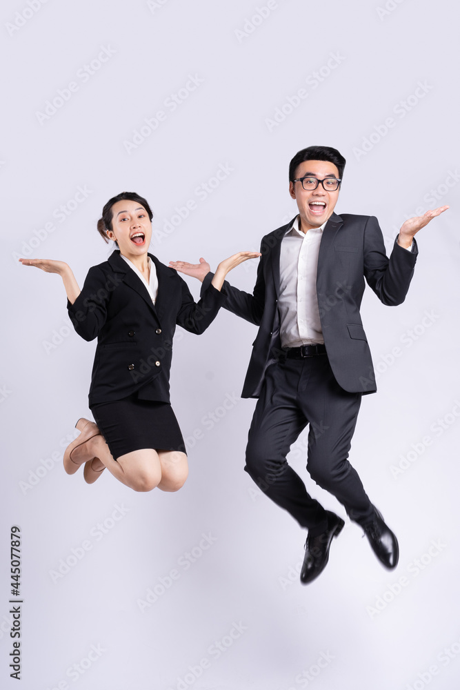 Businessman and business woman jumping on white background