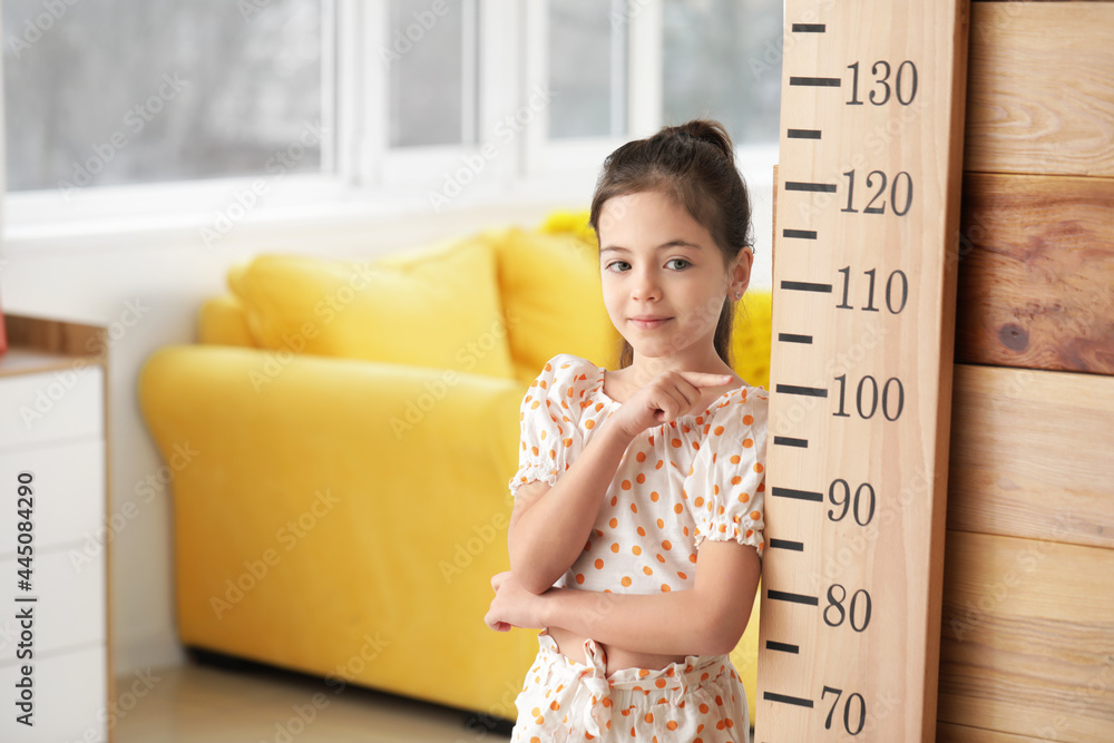 Little girl measuring height at home