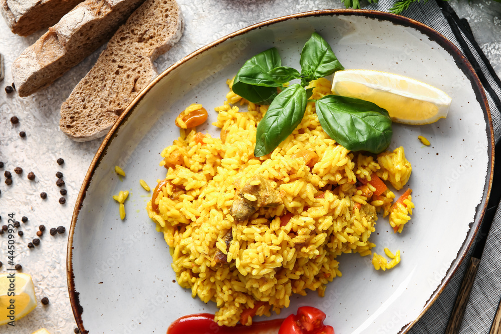 Plate with tasty pilaf on light background