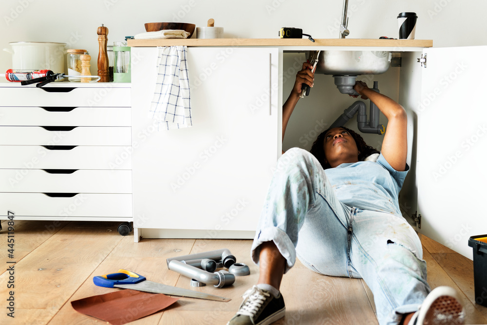 Woman fixing kitchen sink