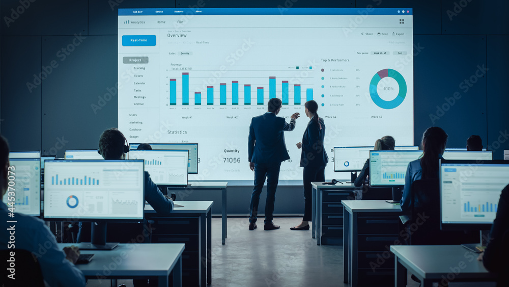 Two Traders Having a Meeting in a Modern Monitoring Office with Analytics Feed on a Big Digital Scre