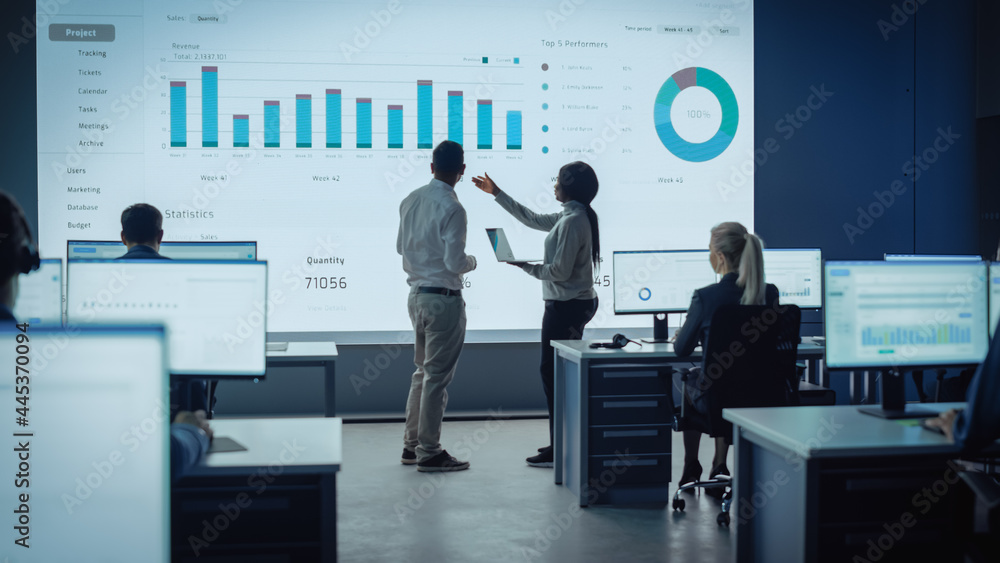 Two Traders Having a Meeting in a Modern Monitoring Office with Analytics Feed on a Big Digital Scre