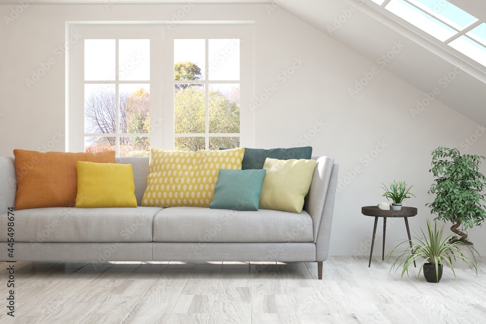 Stylish room in white color with sofa and autumn landscape in window. Scandinavian interior design. 