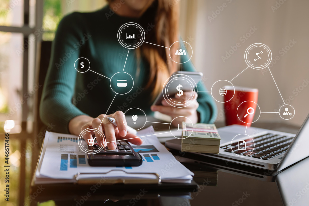 Hands of woman using mobile phone in modern office with laptop and digital tablet