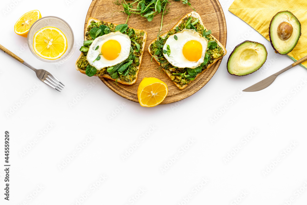 Eggs and avocado with spinach on toasted bread. Top view