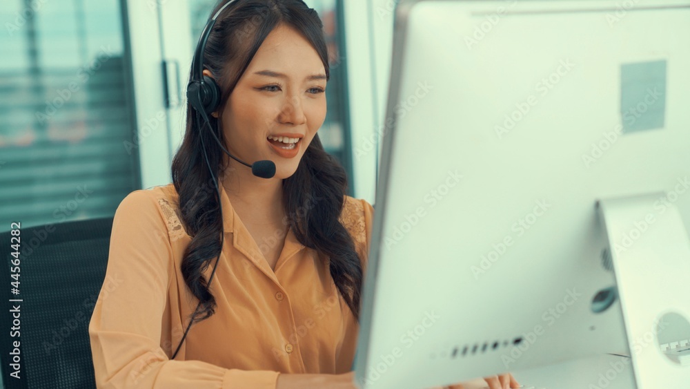 Businesswoman wearing headset working actively in office . Call center, telemarketing, customer supp