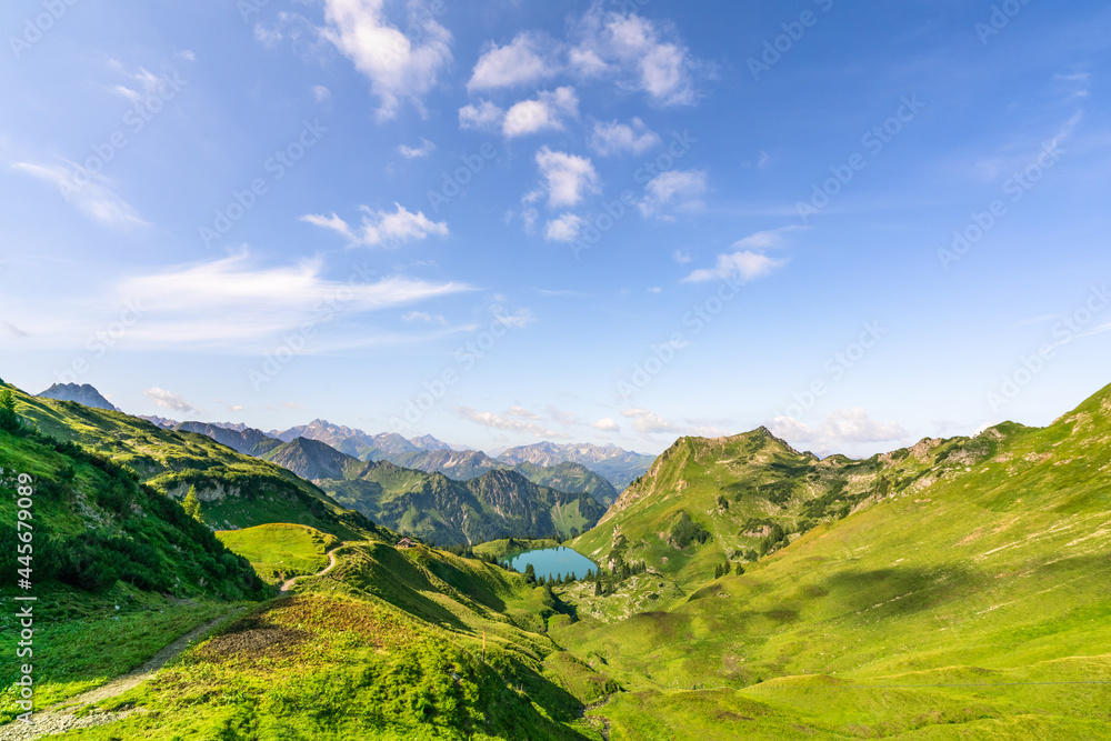 Aerial view of a blue lake on Piz Por under the blue sky and white clouds in the Alps in Switzerland