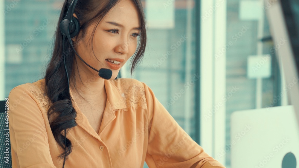 Businesswoman wearing headset working actively in office . Call center, telemarketing, customer supp