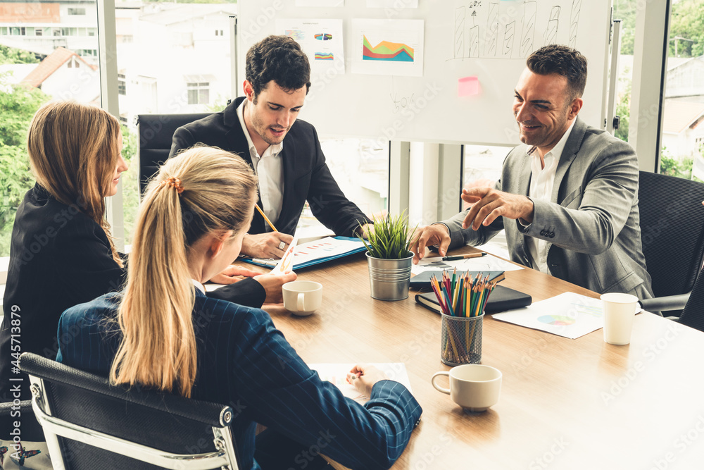 Businessman executive in group meeting discussion with other businessmen and businesswomen in modern