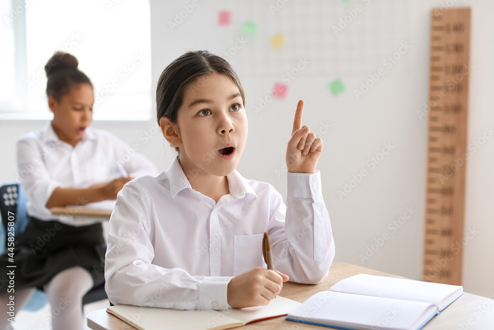 Cute little Asian girl during lesson at school