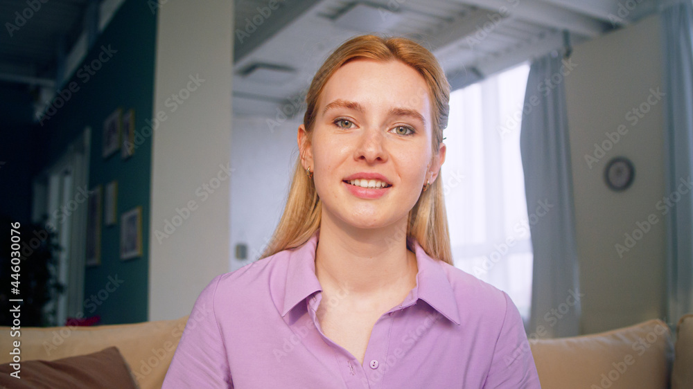 Smiling girl talking to camera making conference video call. Young girl doing video chat for distanc