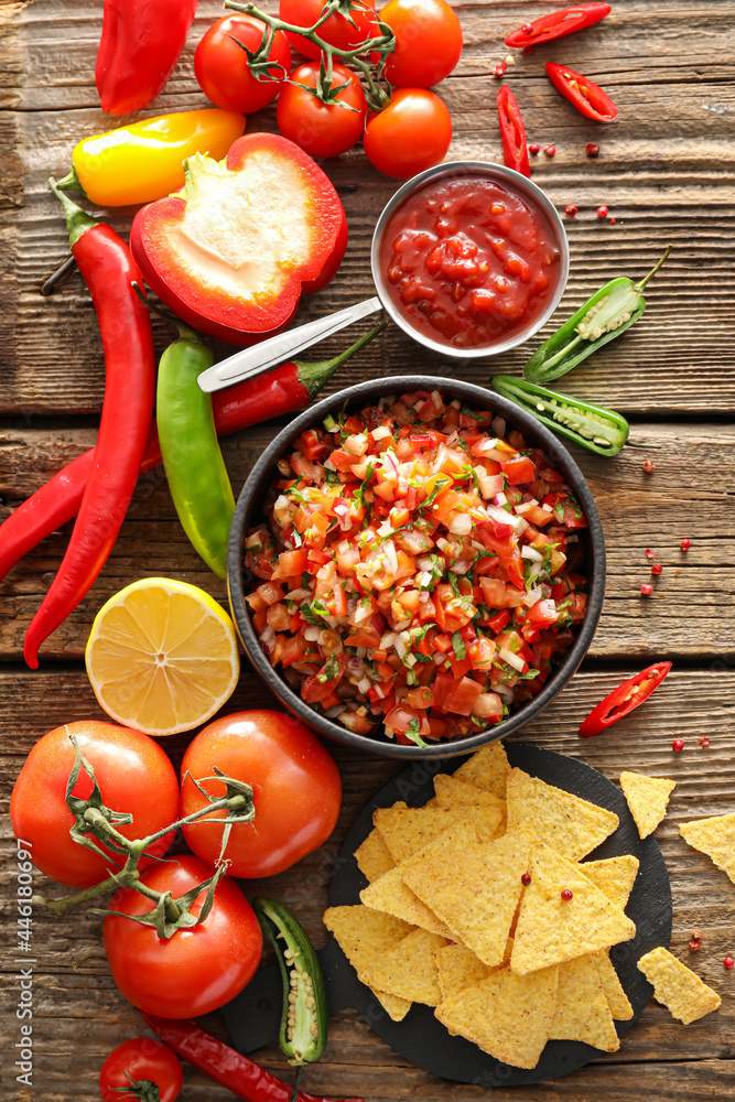 Bowls of tasty salsa sauces on wooden background