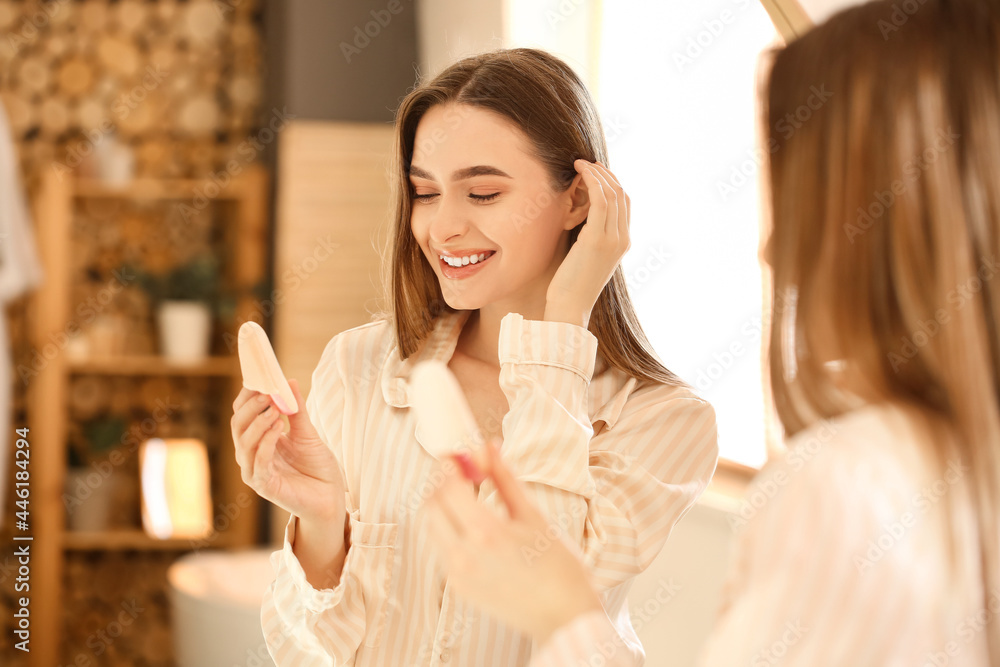 美丽的年轻女子在浴室化妆