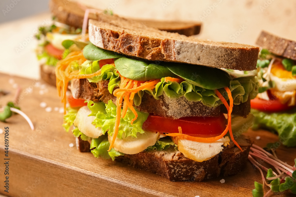 Board with tasty sandwiches on color background, closeup