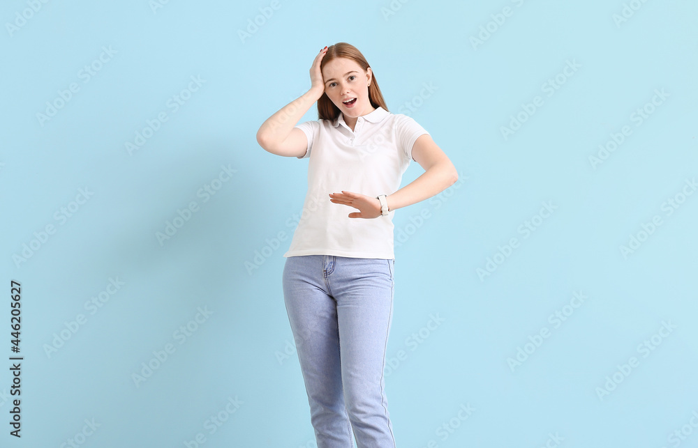 Stressed young woman with wrist watch on color background