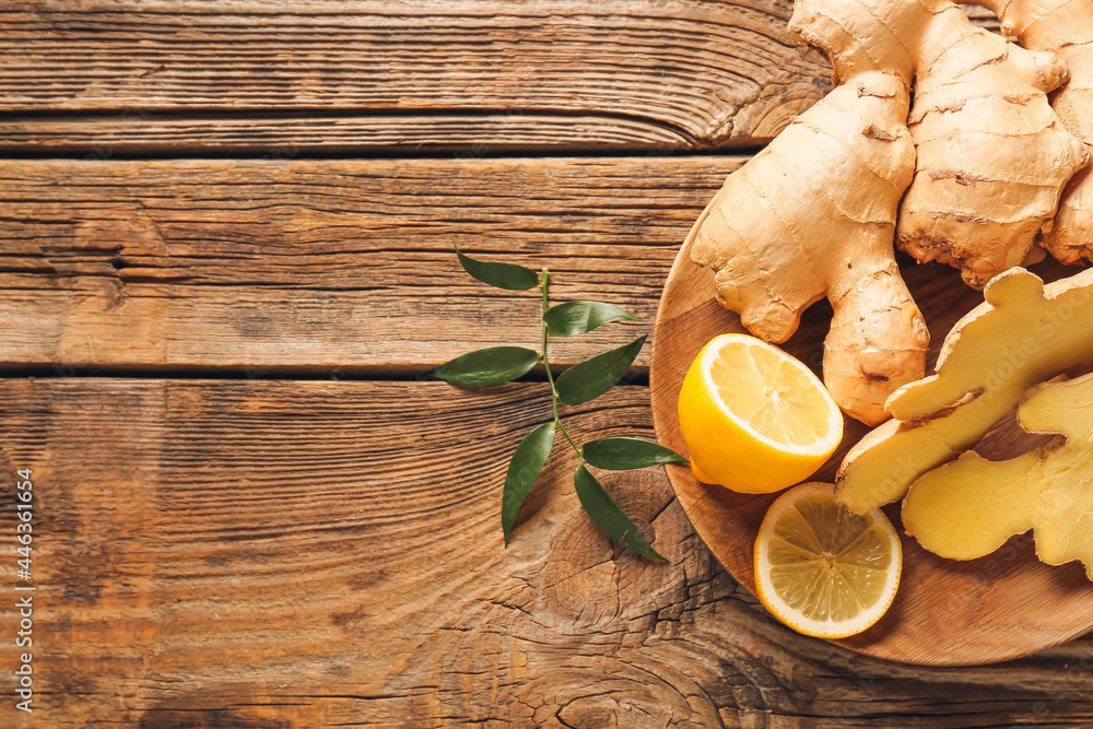 Composition with fresh ginger and lemon on wooden background