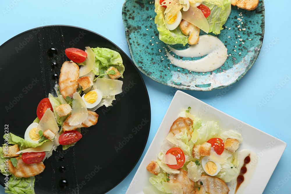 Plates with fresh Caesar salad on color background, closeup