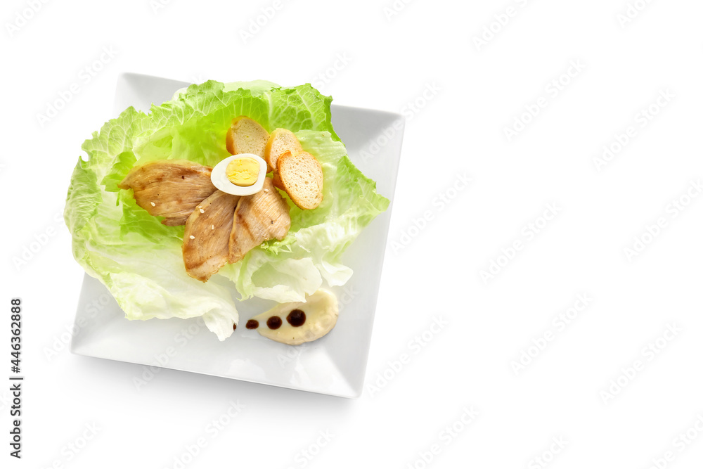 Plate with tasty Caesar salad on white background